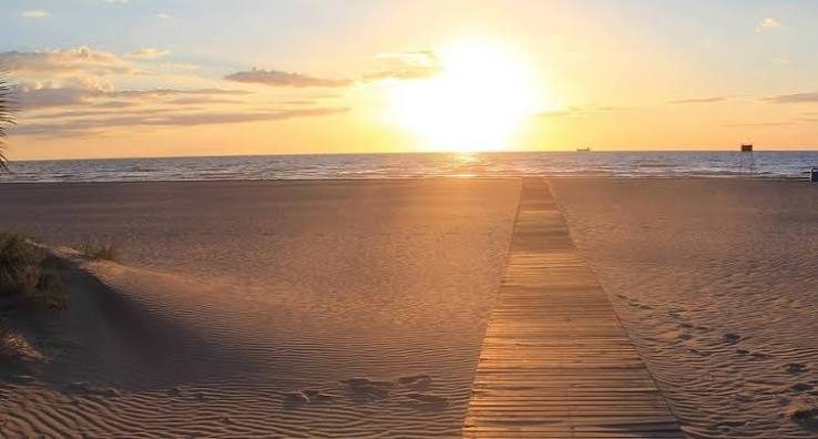 Pasarela de madera entre las dunas de la Playa del Serradal al atardecer, Grao de Castellón
